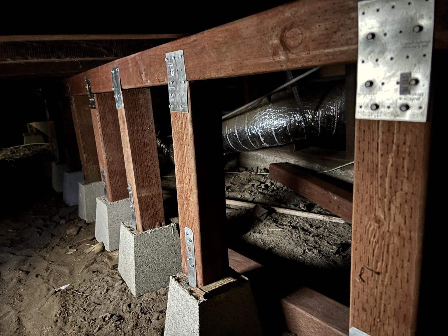 Row of new wood support posts seated on concrete piers