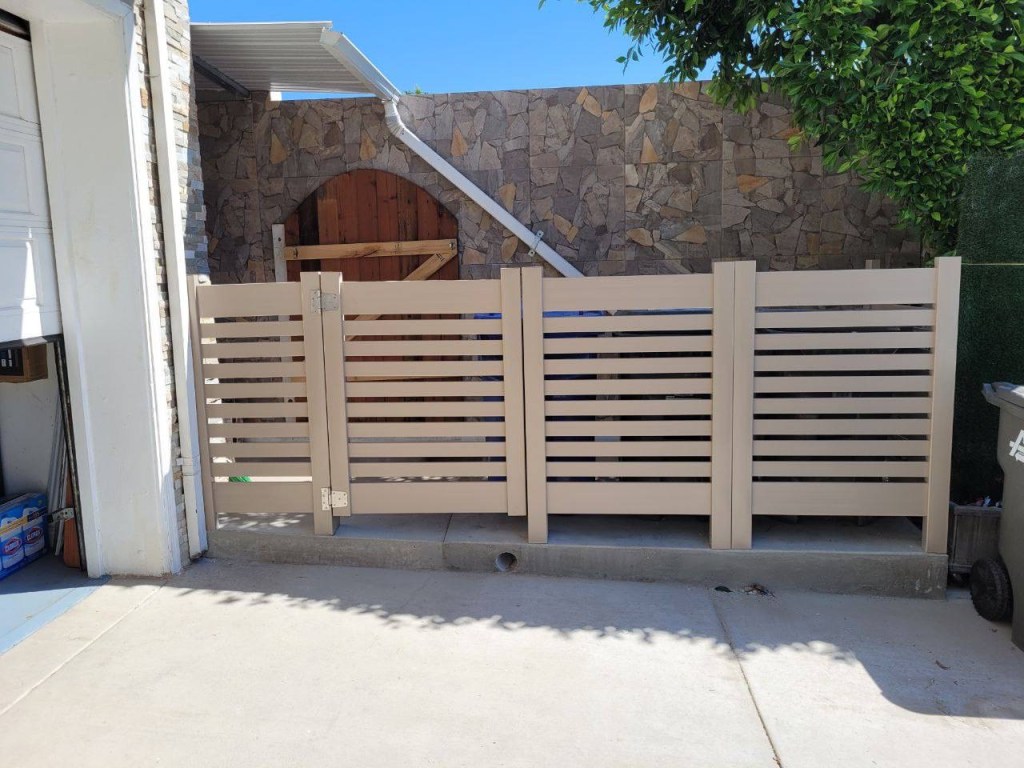 Completed vinyl privacy fence making the trash bins less visible