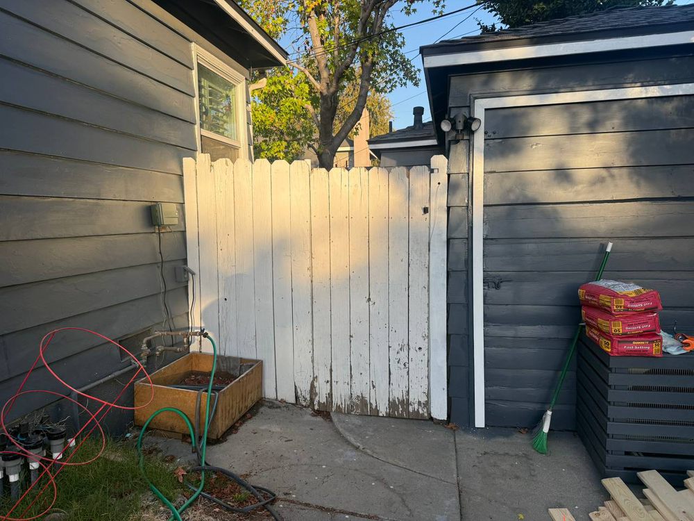 Older painted wooden side gate before replacement